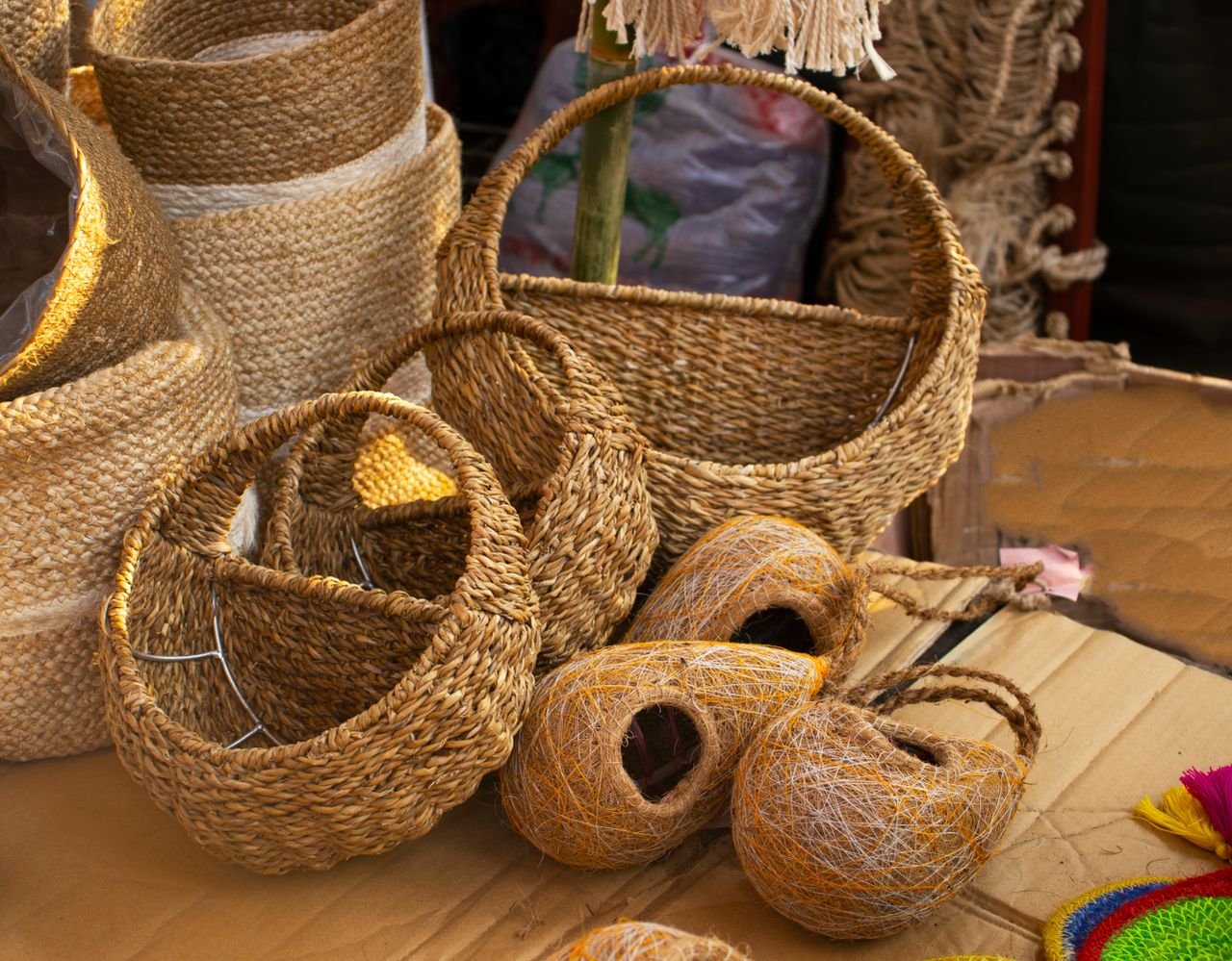 gallery-3 Artisanal woven baskets and handcrafted bird nests for sale at a cultural market.
