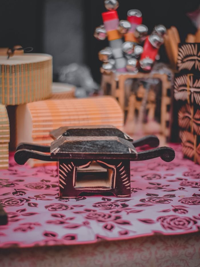 gallery-3 Traditional wooden stamps and crafts on a patterned table in a Rangpur market.