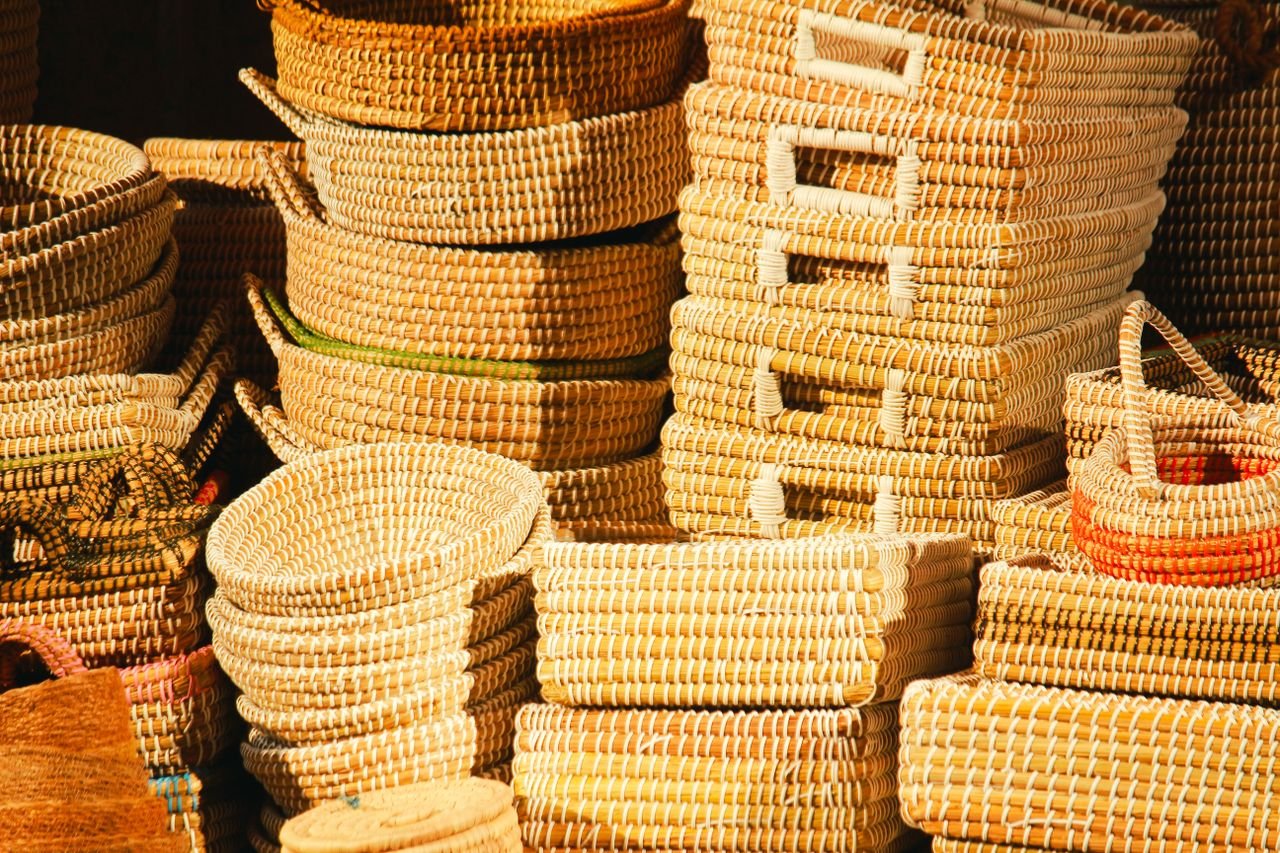 A collection of handwoven baskets displayed in warm sunlight, showcasing artisanship and texture.